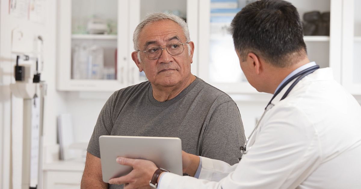 Doctor using digital tablet to discuss results of diagnostic tests with senior cancer patient